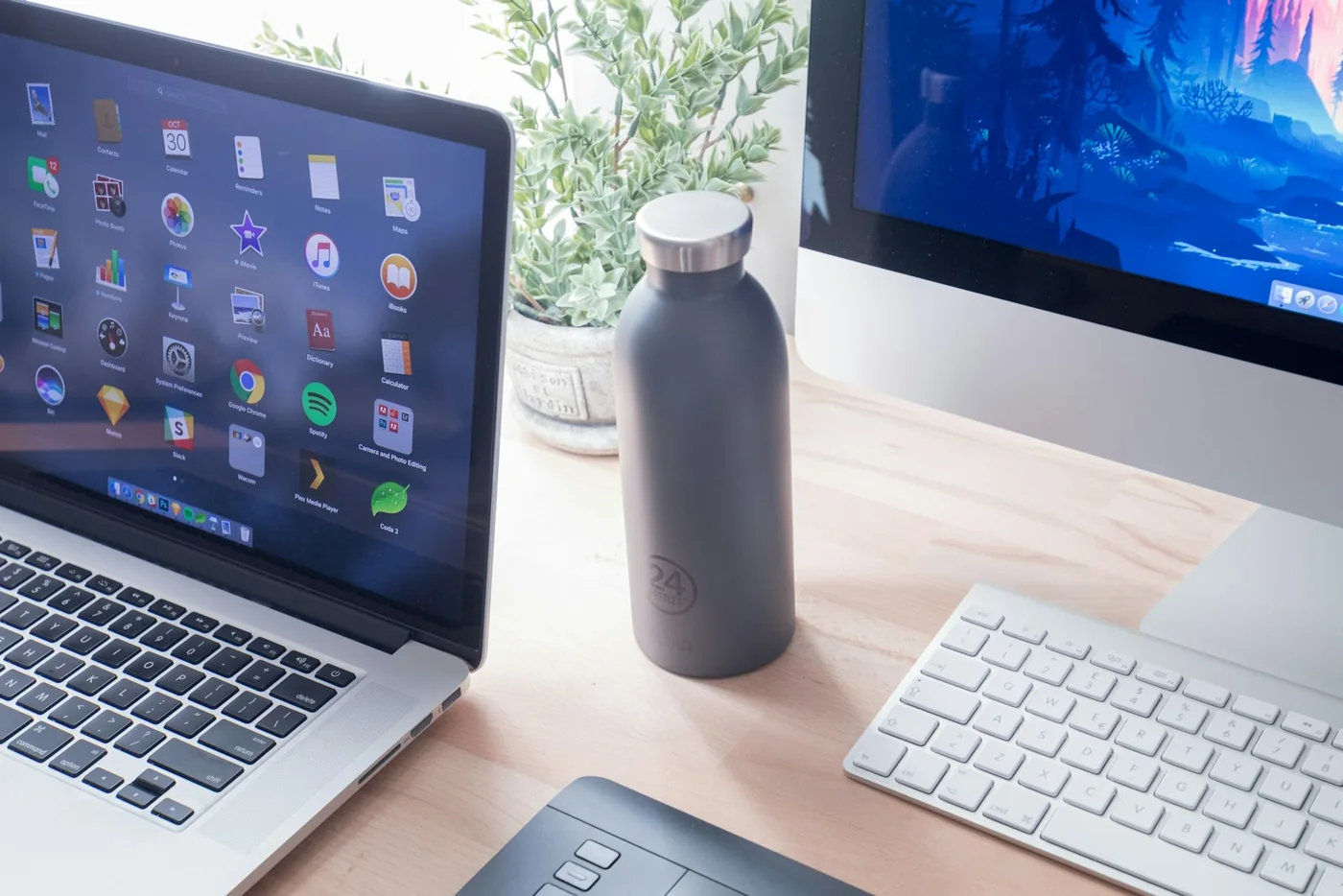 A laptop and keyboard arranged on a bright minimal desk