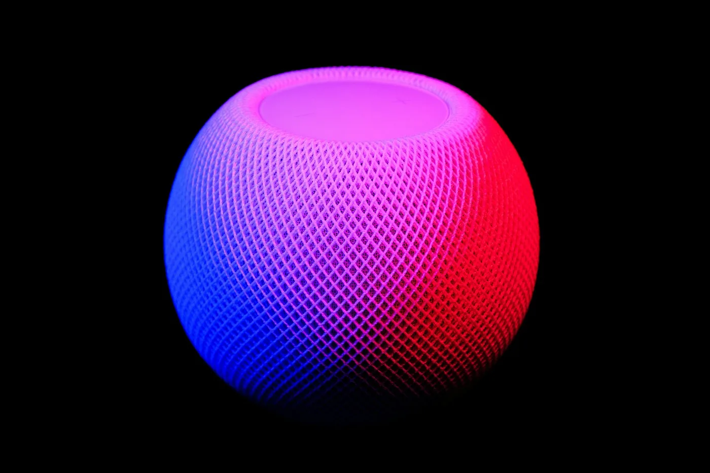 The illuminated top of an original HomePod mini speaker