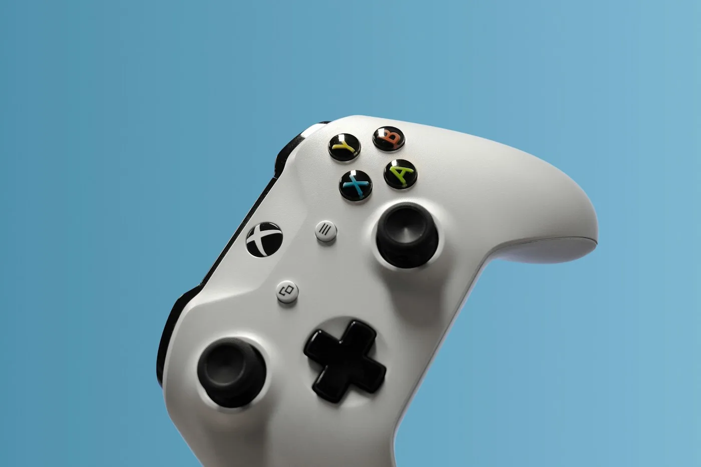 Close-up of a white Xbox controller against a blue background