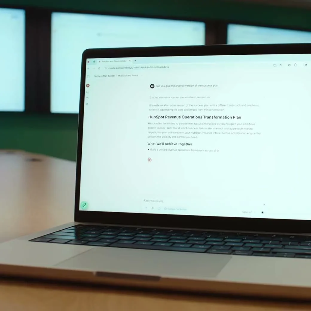 A laptop photographed on a table displaying a written project plan in Claude.