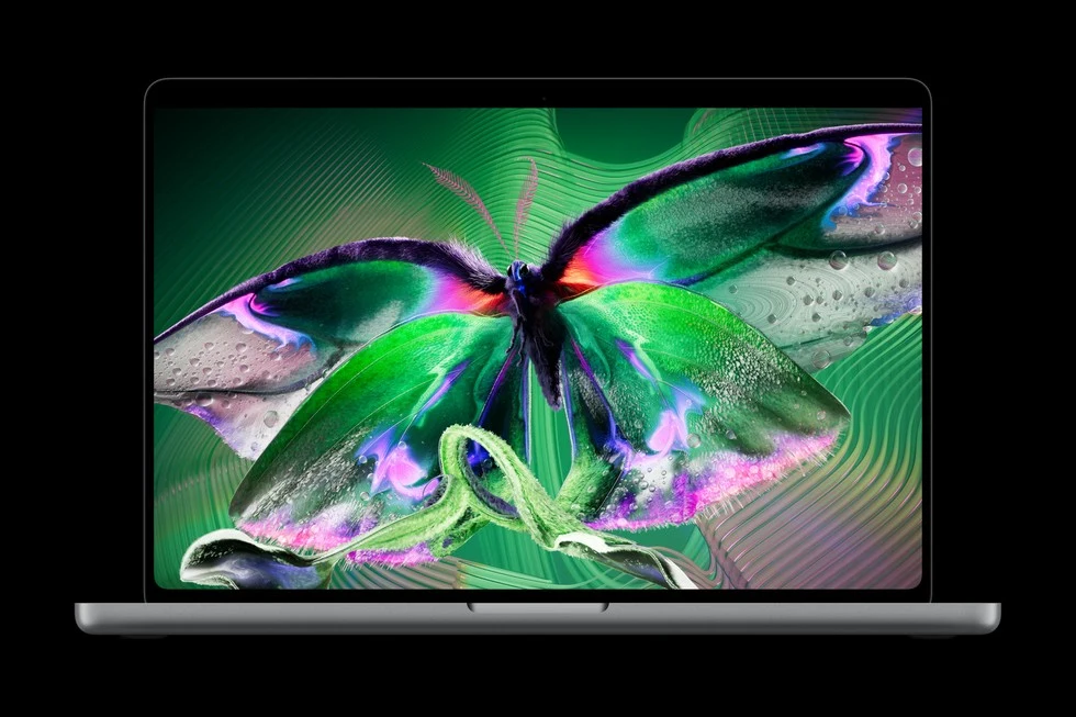 An open MacBook Pro with PROLED XDR Display shows a vibrant butterfly.
